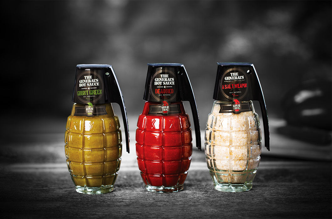 Three grenade shaped glass bottles of hot sauces and sallt